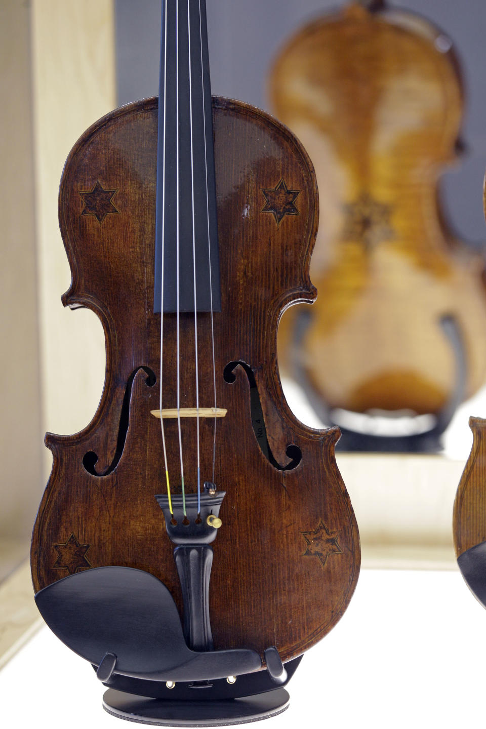 In this April 9, 2012 photo, a violin with five Stars of David is shown on display at the Violins of Hope exhibit at the University of North Carolina in Charlotte, N.C. Eighteen violins recovered from the Holocaust and restored by Israeli violin maker Amnon Weinsten make their U.S. debut on Sunday, April 15. Some were played by Jewish prisoners in Nazi concentration camps, while others belonged to the Jewish Klezmer musical culture. (AP Photo/Chuck Burton)