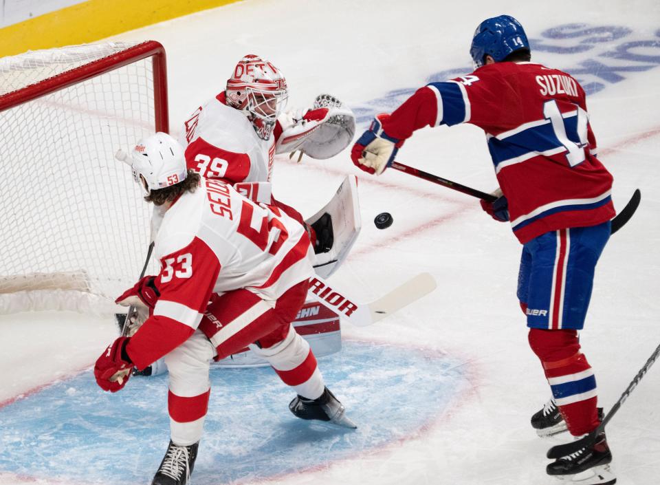 Montreal Canadiens' Nick Suzuki (14) scores on Detroit Red Wings goaltender Alex Nedeljkovic (39) as Red Wings' Moritz Seider (53) watches during the first period of an NHL hockey game Tuesday, Nov. 2, 2021, in Montreal.