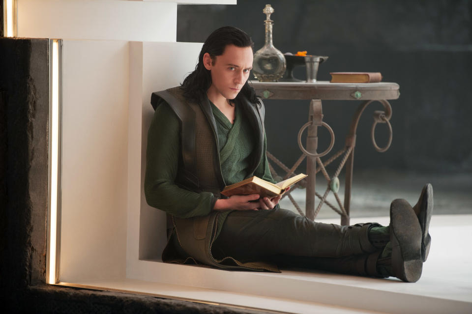 Tom Hiddleston reads a book on a window ledge
