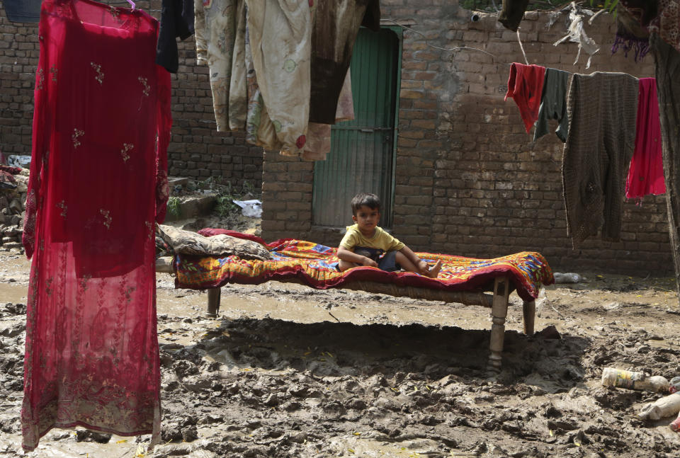 A boy lies on a cot near his flood-hit home, in Charsadda, Pakistan, Wednesday, Aug. 31, 2022. Officials in Pakistan raised concerns Wednesday over the spread of waterborne diseases among thousands of flood victims as flood waters from powerful monsoon rains began to recede in many parts of the country. (AP Photo/Mohammad Sajjad)