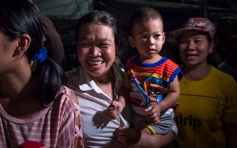 Onlookers at the junction in front of Chiangrai Prachanukroh Hospital watch and cheer as ambulances transport the last rescued schoolboys - Credit: Linh Pham/Getty Images