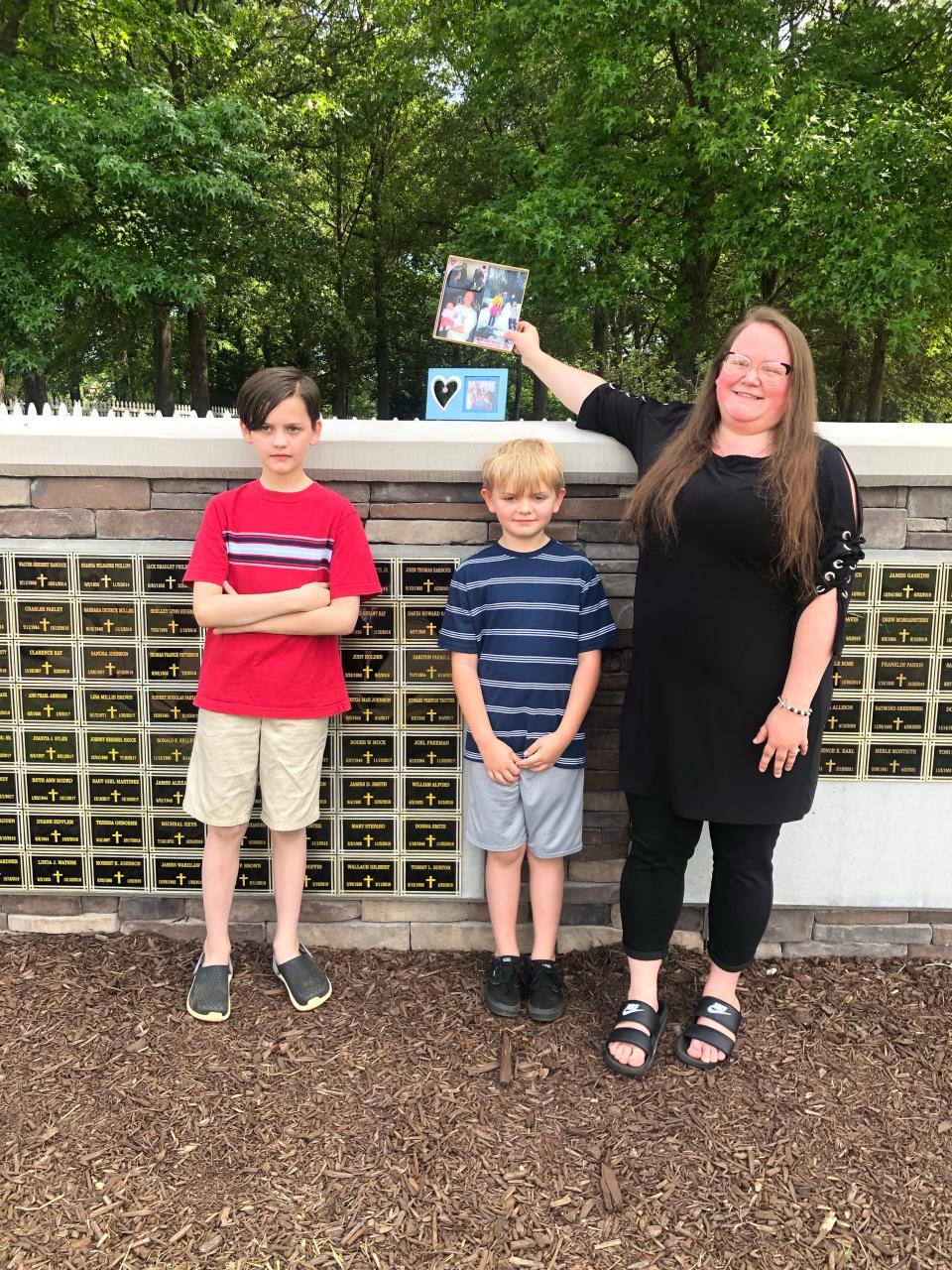 Kelly Beatty stands with her children Keelan and Ela at the memorial site for her stepfather, Chuck Pitts Jr.