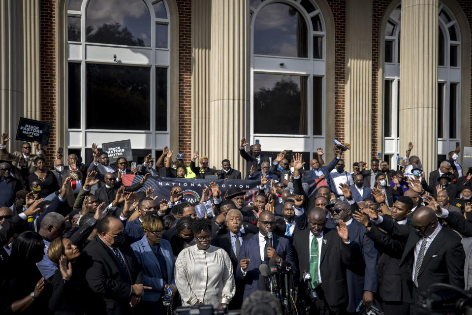 Pastor Jamal Bryant, bottom center, leads a group prayer for to nearly 750 pastors, supporters and family of Ahmaud Arbery gathered outside the Glynn County Courthouse during a Wall of Prayer event, Thursday, Nov. 18, 2021, in Brunswick, Ga. Last week Sharpton's attendance in the trial of Greg McMichael and his son, Travis McMichael, and a neighbor, William "Roddie" Bryan prompted defense attorney Kevin Gough to object to his presence and other Black pastors in court. (AP Photo/Stephen B. Morton)