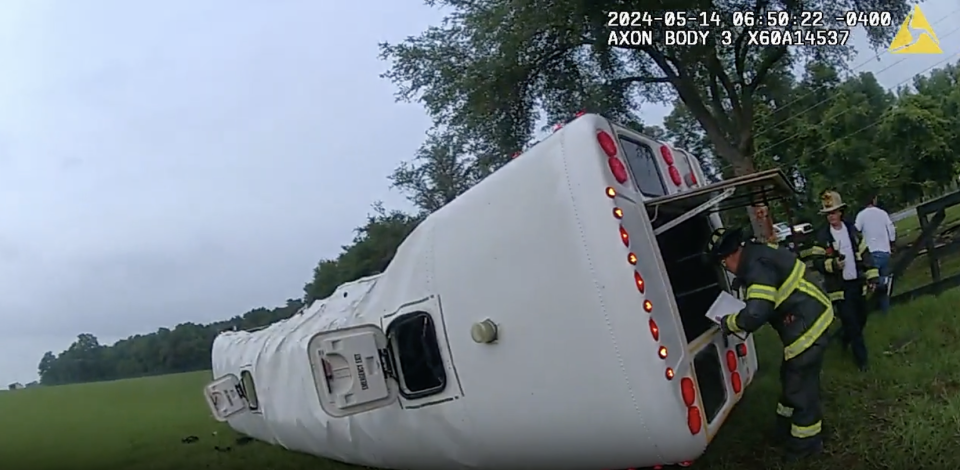 Police body camera footage shows the retired school bus overturned in a field outside Dunnellon, Florida, on Tuesday. / Credit: Marion County Sheriff's Office