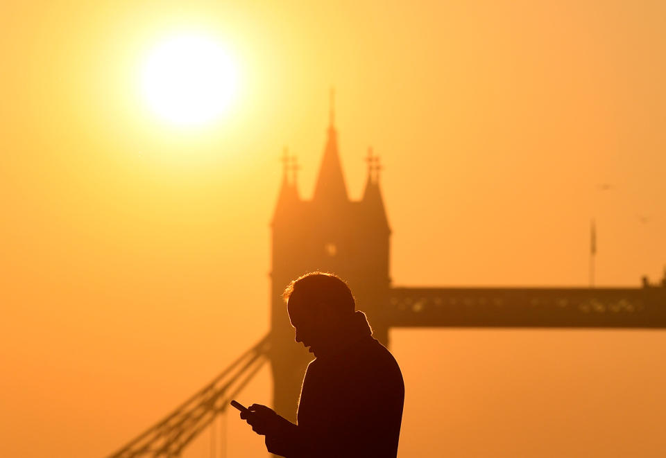 A worker looks at his phone as he crosses London Bridge, with Tower Bridge seen behind during the morning rush hour in the city of London, Britain, February 27, 2019. Photo: REUTERS/Toby Melville