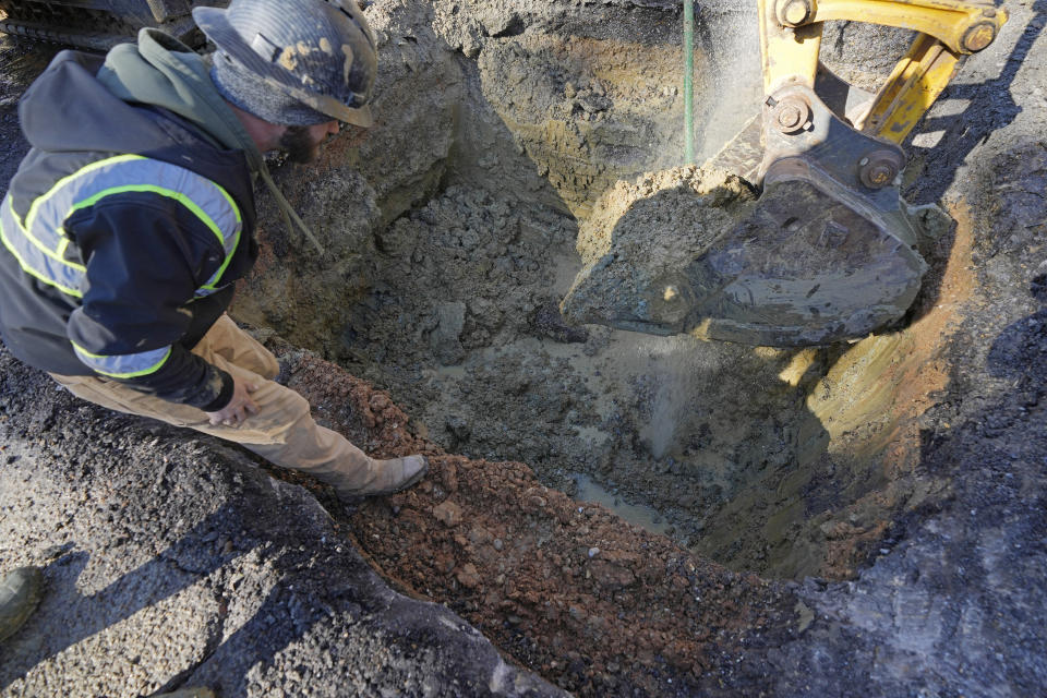 A repair worker surveys the waterline break as his crew begins work on a major street in south Jackson, Miss., Friday, Jan. 19, 2024, a break brought on by a period of freezing weather. Law enforcement agencies are investigating whether social media rumors about a potential water outage prompted people to quickly fill bathtubs with tap water in Mississippi's capital during a cold snap and cause a drop in pressure that temporarily made faucets run dry for thousands of customers on the city's long-troubled system. (AP Photo/Rogelio V. Solis)