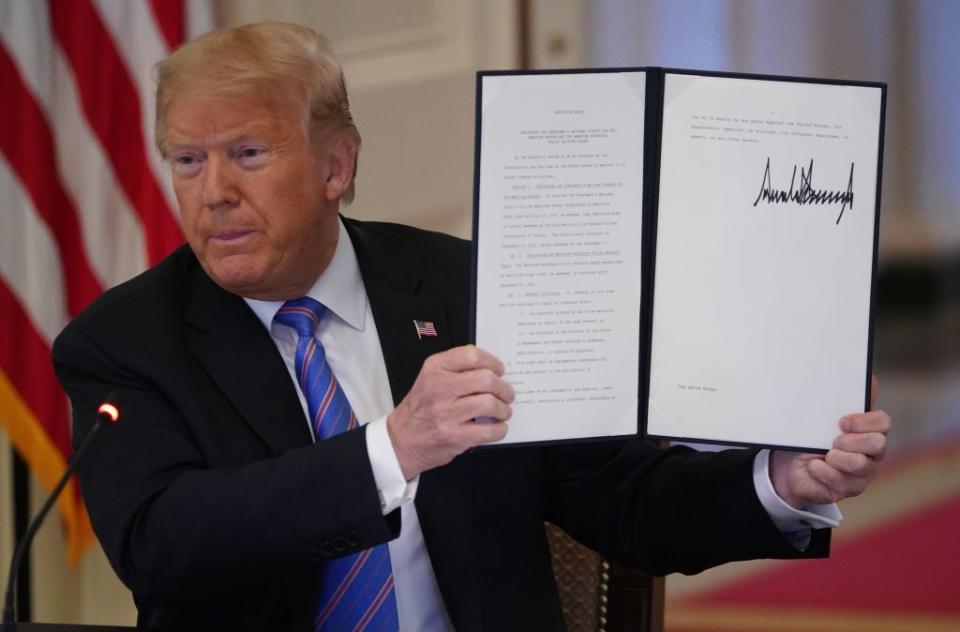 US President Donald Trump holds up an Executive Order he signed in June. Source: Getty