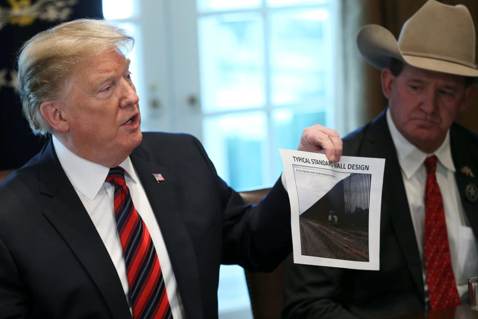 U.S. President Donald Trump shows a photo of a "typical" border wall design during a "roundtable discussion on border security and safe communities" with state, local, and community leaders at the White House on January 11, 2019. (Photo: REUTERS/Leah Millis)