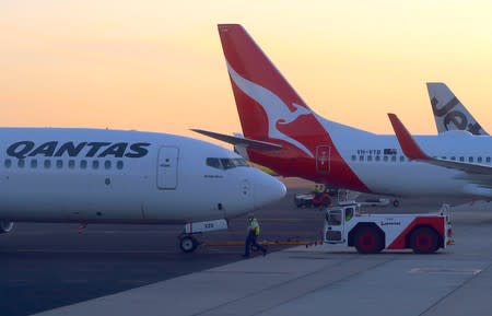 FILE PHOTO - Workers are seen near Qantas Airways, Australia's national carrier, Boeing 737-800 aircraft on the tarmac at Adelaide Airport