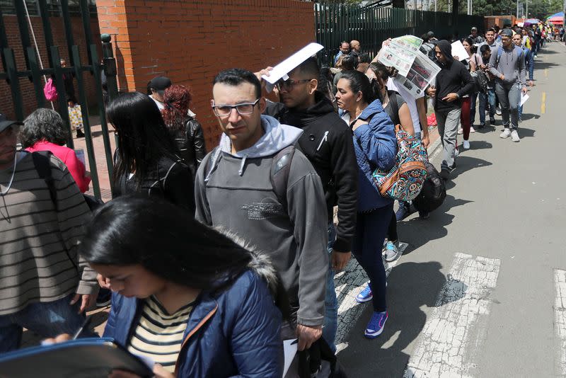 FOTO DE ARCHIVO. Personas hacen fila para presentar sus hojas de vida en búsqueda de una oportunidad de empleo durante una fería laboral en Bogotá