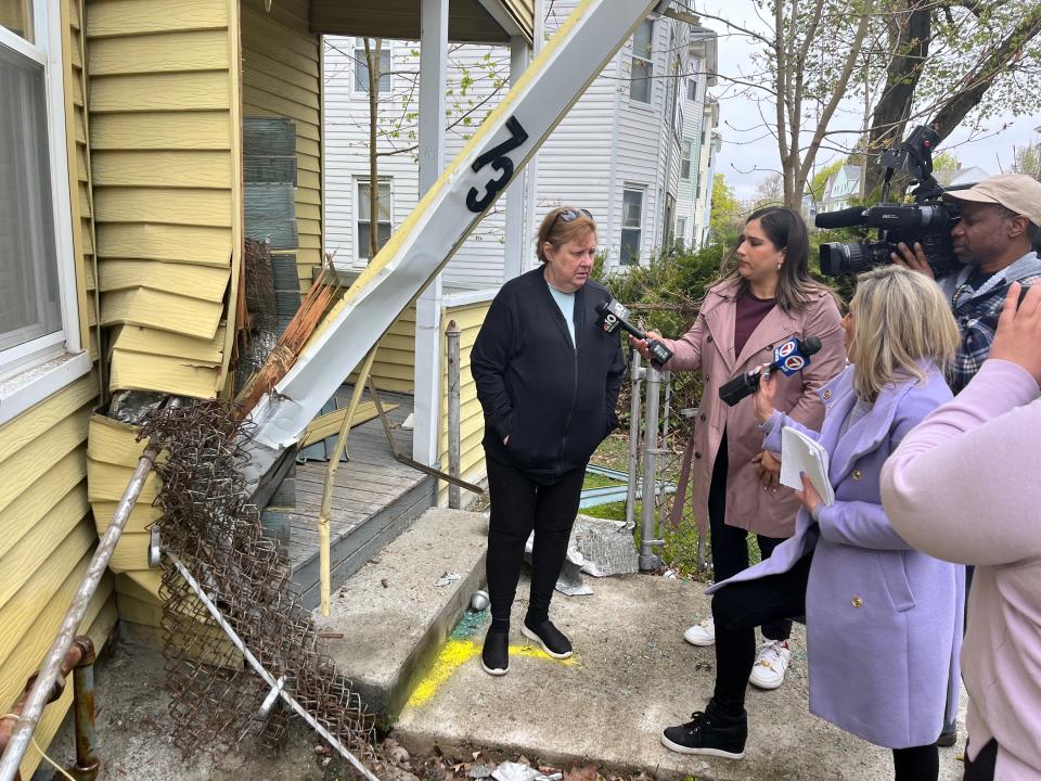 Lorrie Carlson of a 73 Paine St., with reporters outside her apartment, recounts the events of Tuesday night.