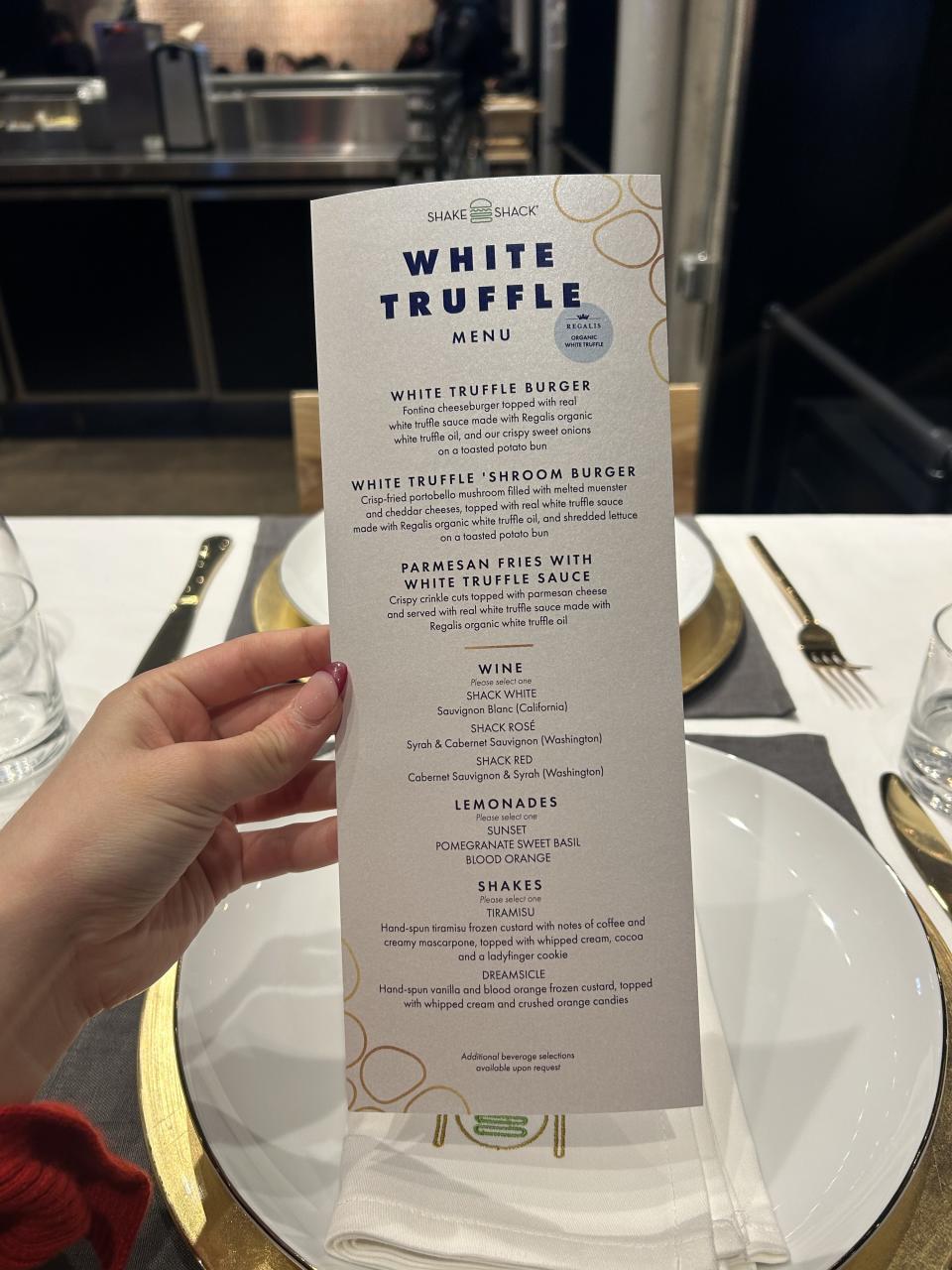 A hand holding the White Truffle Menu