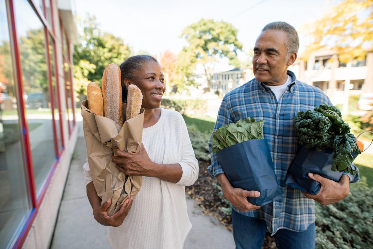 senior couple walking outdoor with groceries