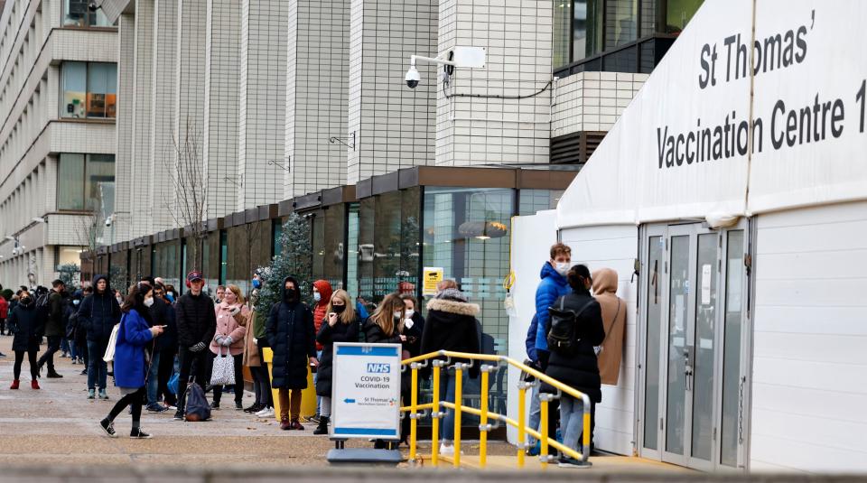 Members of the public queue to receive a dose of a Covid-19 vaccine at a coronavirus vaccination centre outside Guy's and St Thomas' Hospital in central London on December 13, 2021. - UK Prime Minister Boris Johnson on Monday said at least one person infected with Omicron had died, as the country began an ambitious booster programme against the variant. (Photo by Tolga Akmen / AFP) (Photo by TOLGA AKMEN/AFP via Getty Images)