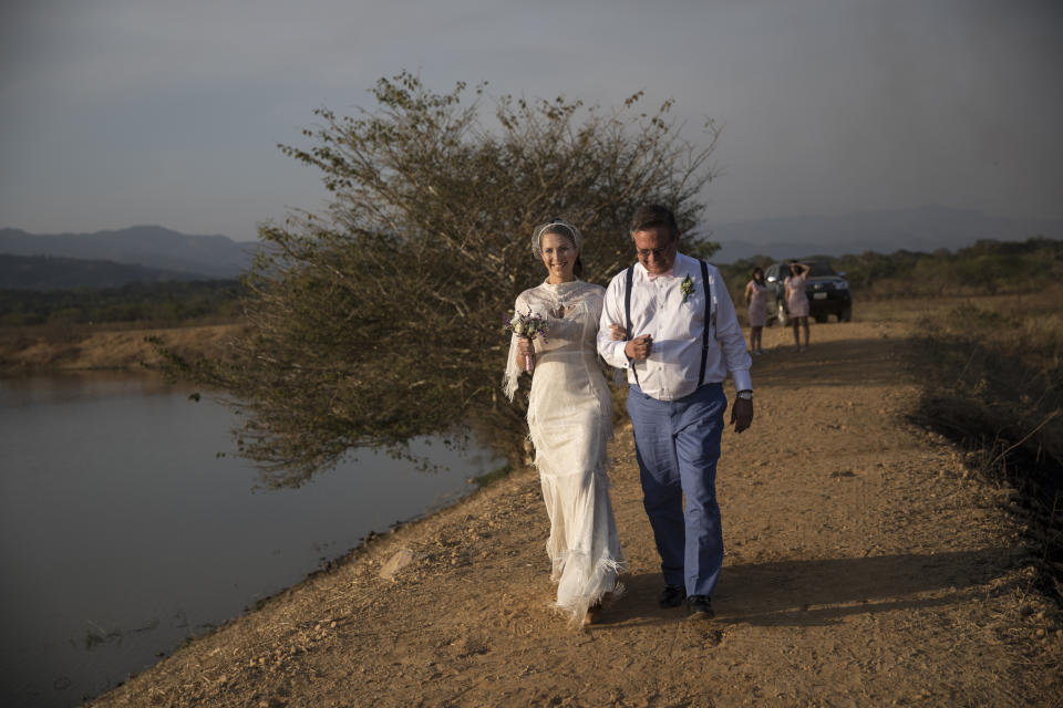 Acompañada de su padre, Ricardo Vera, María Fernanda Vera va al encuentro de su novio Juan José Pocaterra en la boda campestre de ambos en una hacienda de Acarigua, Venezuela, el 16 de febrero del 2019. (AP Photo/Rodrigo Abd)