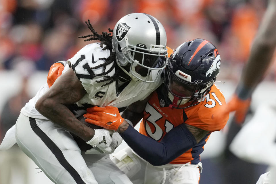 Las Vegas Raiders wide receiver Davante Adams (17) gets tackled by Denver Broncos safety Justin Simmons (31) during the second half of an NFL football game, Sunday, Sept. 10, 2023, in Denver. (AP Photo/David Zalubowski)