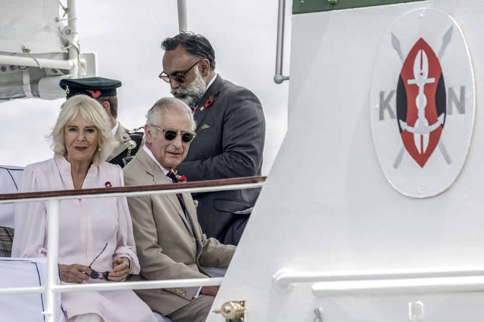 Britain's King Charles III, center, and Queen Camilla arrive aboard the Admiral's Barge to meet Royal Marines and Kenyan Marines at Mtongwe Naval Base, in Mombasa, Kenya, Thursday, Nov. 2, 2023. (Luis Tato/Pool Photo via AP)