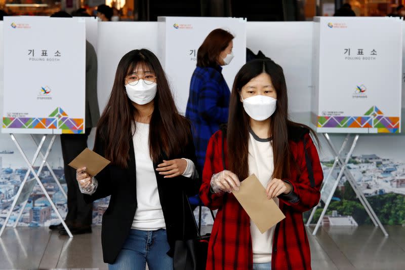 Voters cast absentee ballots for the parliamentary election at a polling station in Seoul