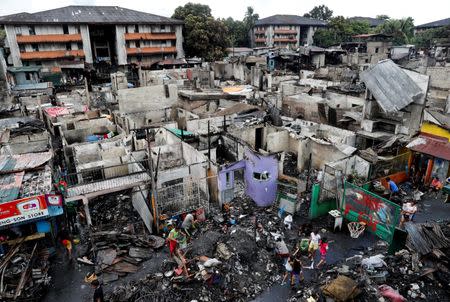 Fire victims collect recyclable materials after a fire at a residential district in Quezon City, Metro Manila, Philippines, March 8, 2018. REUTERS/Erik De Castro