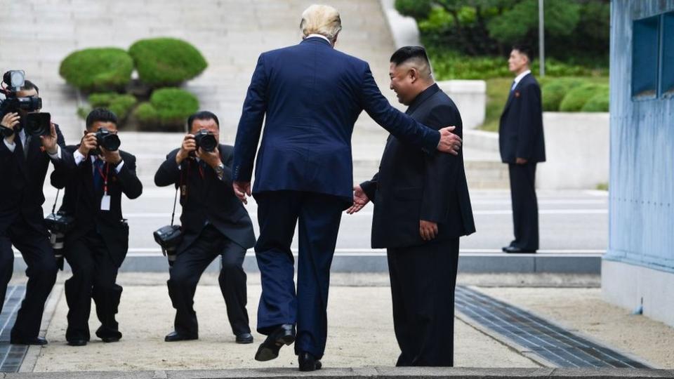 Trump cruzando hacia el lado norte de la línea divisoria entre las dos Coreas.