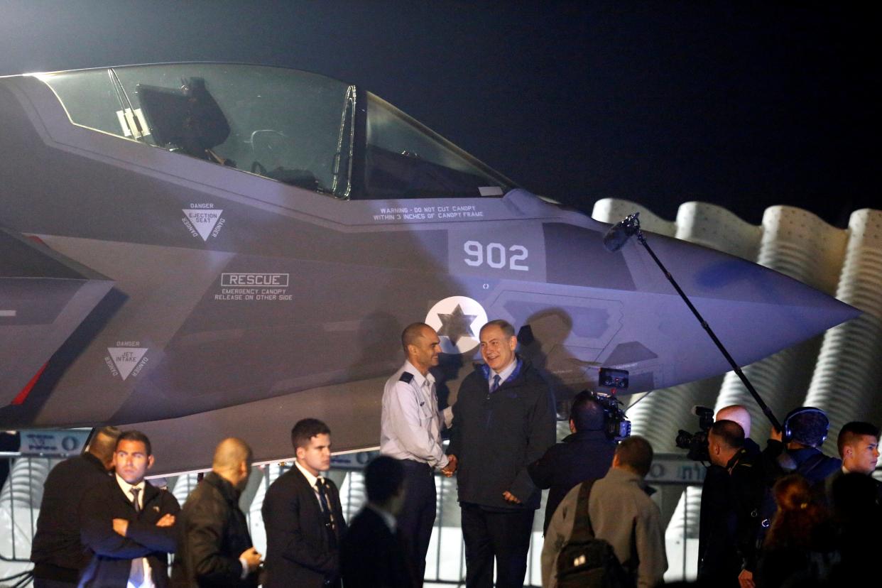 Israeli Prime Minister Benjamin Netanyahu stands next to a F-35 fighter jet just after it landed in Israel at Nevatim air base  in 2016