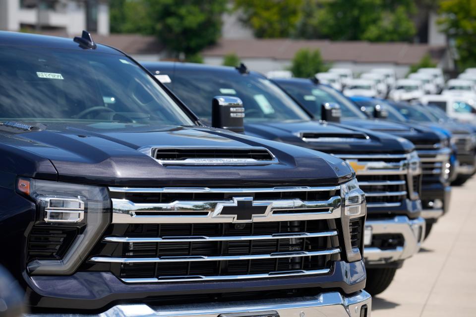 Unsold 2023 Silverado pickup trucks sit in a long row at a Chevrolet dealership on June 18, 2023, in Englewood, Colo.