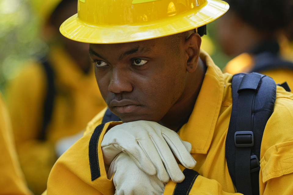 Kai Todd rests as he listens to instructions during a wildland firefighter training Friday, June 9, 2023, in Hazel Green, Ala. A partnership between the U.S. Forest Service and four historically Black colleges and universities is opening the eyes of students of color who had never pictured themselves as fighting forest fires. (AP Photo/George Walker IV)