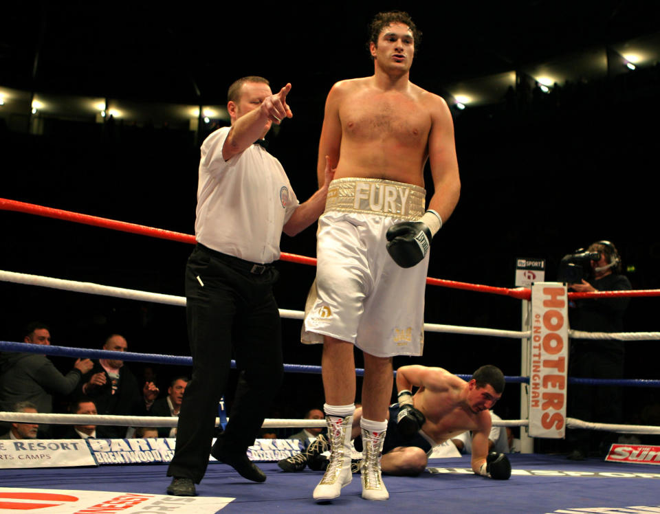 Tyson Fury (centro) de Gran Bretaña es conducido lejos por el árbitro después de noquear a Bela Gyongyosi de Hungría en su debut profesional durante su victoria en la primera ronda en el Trent FM Arena, Nottingham.  (Foto de Nick Potts - PA Images/PA Images vía Getty Images)