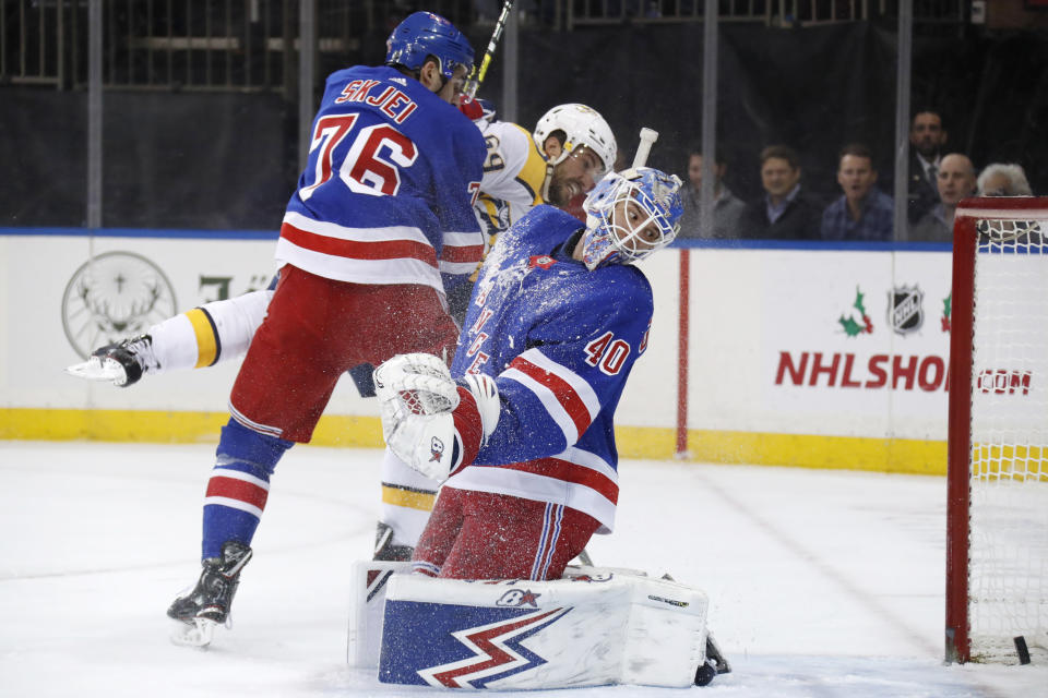 New York Rangers goaltender Alexandar Georgiev (40) watches as the puck goes into the net for a goal as Rangers defenseman Brady Skjei (76) sends Nashville Predators defenseman Roman Josi (59) flying during the first period of an NHL hockey game, Monday, Dec. 16, 2019, in New York. The goal was scored by Nashville Predators right wing Rocco Grimaldi, not shown. (AP Photo/Kathy Willens)