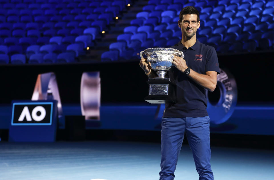 Defending men's singles champion Serbia's Novak Djokovic holds the Norman Brookes Challenge Cup during the official draw ceremony on Margaret Court Arena ahead of the Australian Open tennis championship in Melbourne, Australia, Thursday, Jan. 16, 2020. (AP Photo/Mark Baker)