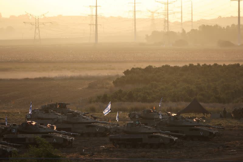 Una formación de tanques israelíes y personal militar se posiciona cerca de la frontera de Israel con la Franja de Gaza