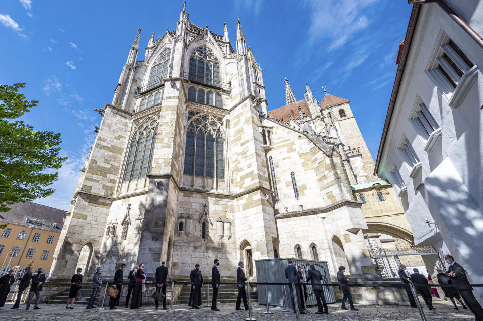 Guests of the funeral service for Priest Georg Ratzinger line up in front of St. Peter's Cathedral in Regensburg, Germany, Wednesday, July 8, 2020. The elder brother of the emeritus Pope Benedict XVI had died on July 1 at the age of 96 years. (Armin Weigel/dpa via AP)