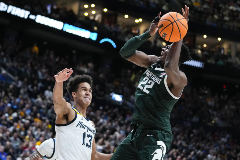 Michigan State center Mady Sissoko (22) shoots over Marquette forward Oso Ighodaro (13) in the second half of a second-round college basketball game in the men's NCAA Tournament in Columbus, Ohio, Sunday, March 19, 2023. (AP Photo/Michael Conroy)