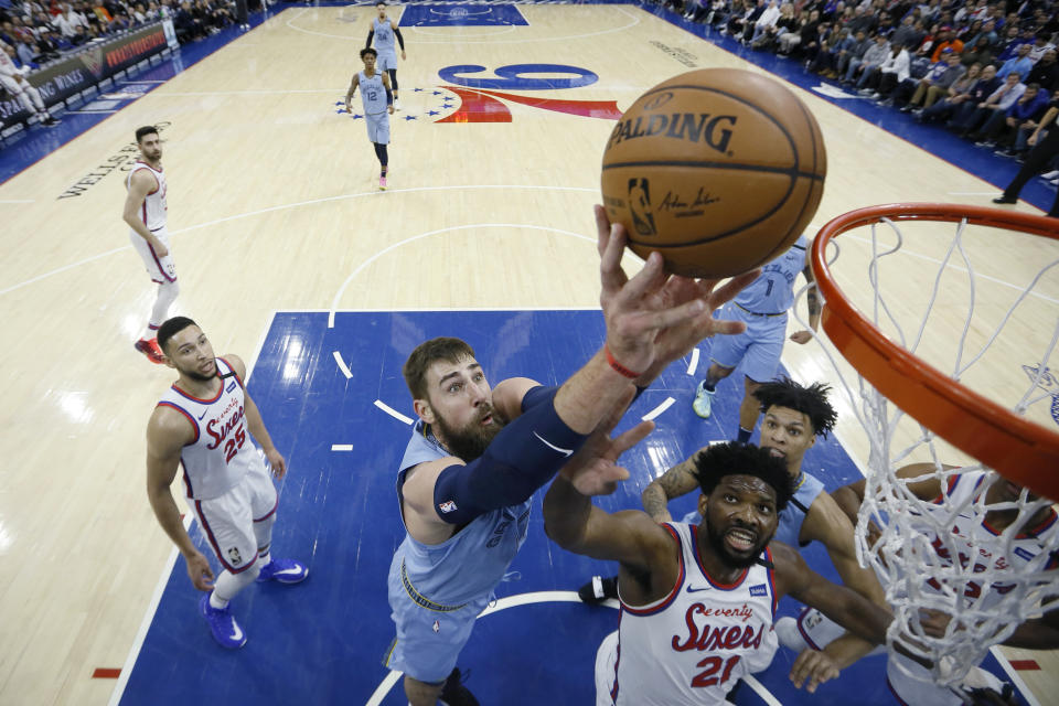 Memphis Grizzlies' Jonas Valanciunas, center, goes up for a shot against Philadelphia 76ers' Joel Embiid during the first half of an NBA basketball game Friday, Feb. 7, 2020, in Philadelphia. (AP Photo/Matt Slocum)