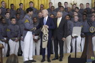 President Joe Biden is presented a team jersey by team captain Jimmy Ciarlo, as head coach Jeff Monken, right, looks on, during an event to present the Commander-in-Chief's Trophy to the United States Military Academy Army Black Knights, in the East Room of the White House, Monday, May 6, 2024, in Washington. (AP Photo/Evan Vucci)