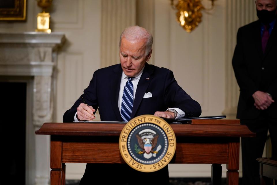 President Joe Biden signs an executive order on climate change, in the State Dining Room of the White House, Wednesday, Jan. 27, 2021, in Washington. (AP Photo/Evan Vucci)