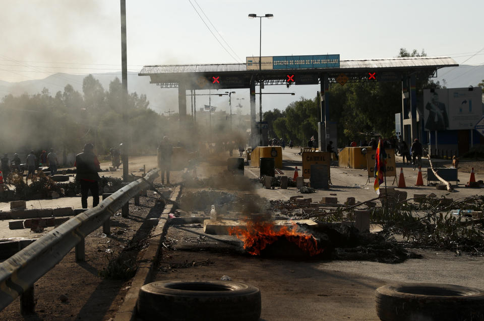 Tires burn at a toll station in Sacaba, Bolivia, Saturday, Nov. 16, 2019. Bolivia’s political crisis turned deadly after security forces opened fire on supporters of former President Evo Morales in Sacaba Friday, killing at least five people, injuring dozens and threatening the interim government’s efforts to restore stability following the resignation of the former president in an election dispute. (AP Photo/Juan Karita)