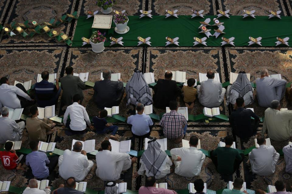 <p>Men read the Quran at the Imam Hussein shrine during the Muslim holy month of Ramadan in the city of Karbala, Iraq, May 29, 2017. (Stringer/Reuters) </p>