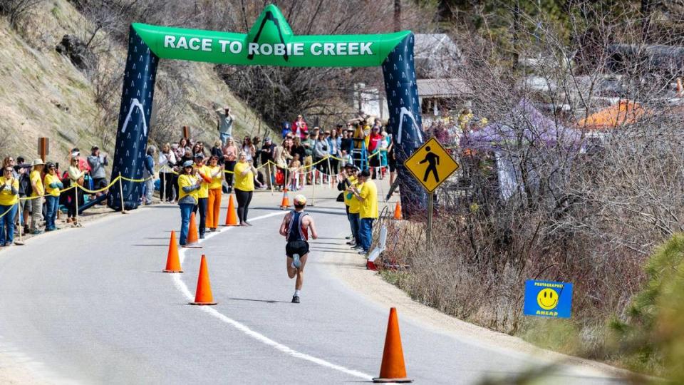 Volunteers at the Race to Robie Creek finish line clap for runners, Saturday, April 15, 2023.