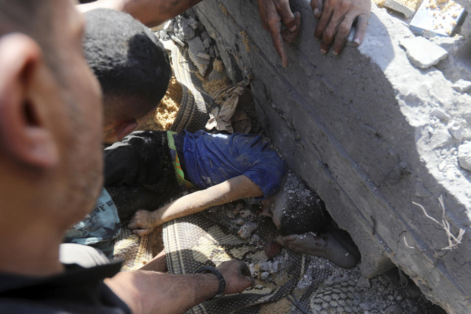 Palestinians try to pull out a body of a dead person from under the rubble of a destroyed building following Israeli airstrikes on town of Khan Younis, southern Gaza Strip, Thursday, Oct. 26, 2023. (AP Photo/Mohammed Dahman)