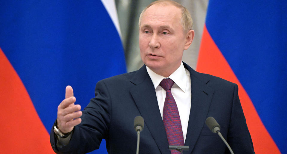 Russian President Vladimir Putin stands at a podium during an address.