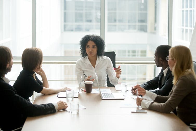 Director addressing staff in a boardroom meeting