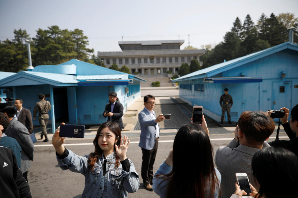 Unos surcoreanos se toman selfies mientras recorren el pueblo de Panmunjom, en la zona desmilitarizada que separa las dos Coreas, el 1 de mayo. (Foto: Kim Hong-Ji / Reuters).