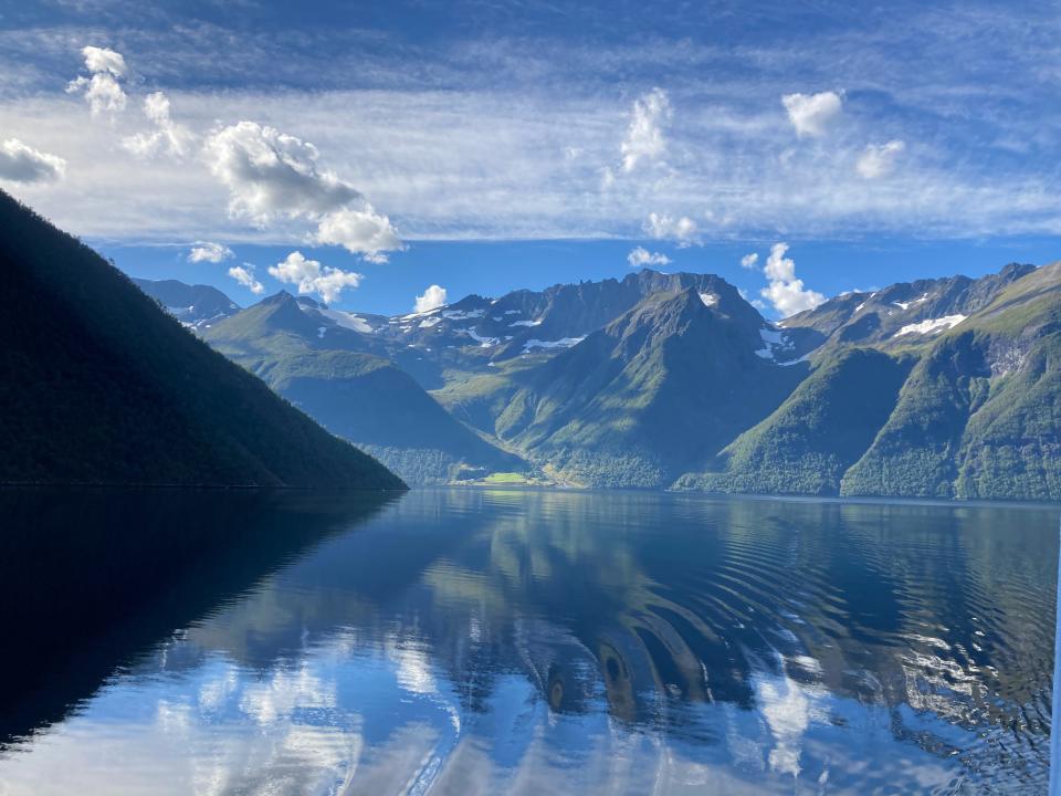 View of Hjorundfjord mountains and skies reflecting onto clear water