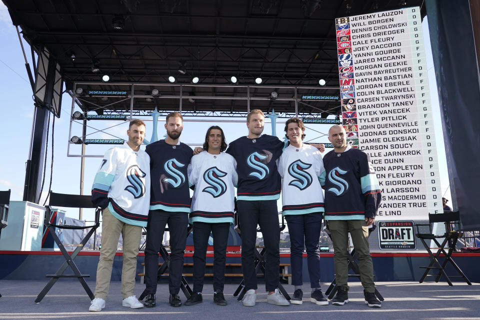 Seattle Kraken NHL hockey players Jordan Eberle, Chris Dreidger, Brandon Tanev, Jamie Oleksiak, Hadyn Fluery and Mark Giordano, from left, pose for a photo Wednesday, July 21, 2021, after being introduced during the Kraken's expansion draft event in Seattle. (AP Photo/Ted S. Warren)