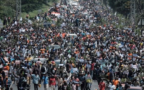 Supporters of Kenyan's opposition party National Super Alliance (NASA) leader Raila Odinga march with his convoy upon his arrival to the Jomo Kenyatta international airport on November 17 - Credit: AFP