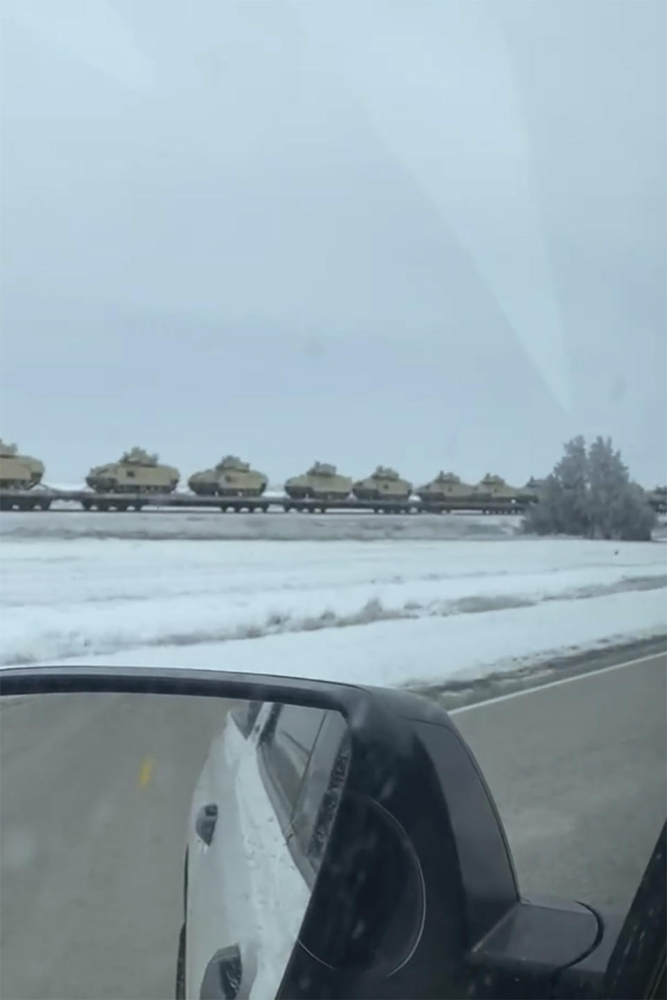 This image from video provided by Eddie Johnson shows a line of tanks and other military combat vehicles traveling by rail along a snowy field along Highway 40 outside of Gorham, Kansas. On Friday, Jan. 27, 2023, The Associated Press reported on stories circulating online incorrectly claiming the video showed a train transporting American tanks and infantry fighting vehicles in Poland, after President Joe Biden announced the U.S. would send tanks to Ukraine. (Eddie Johnson via AP)