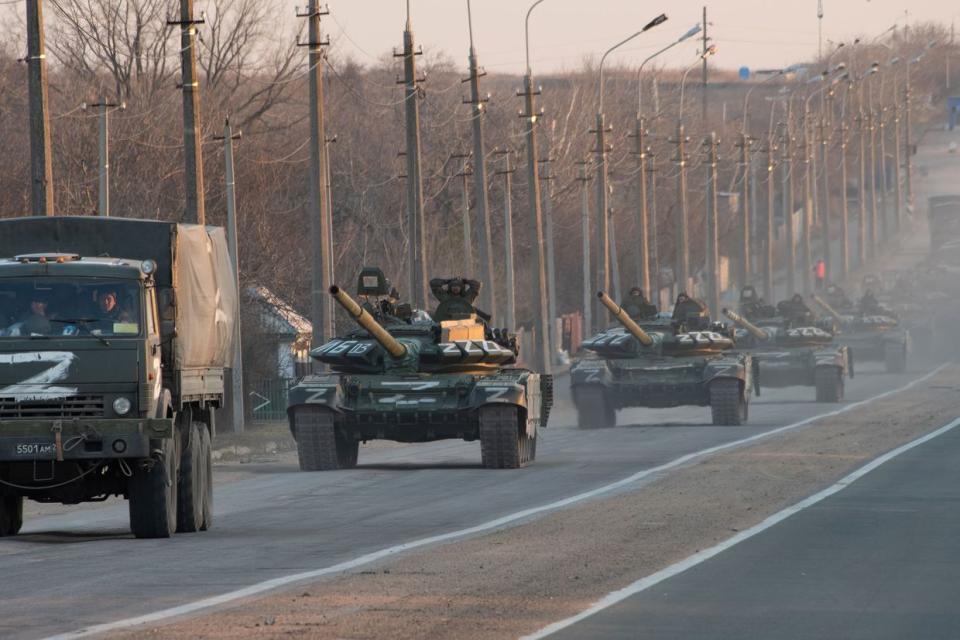 A column of tanks marked with the Z symbol stretches into the distance as they proceed northwards along the Mariupol-Donetsk highway in Mariupol, Ukraine. (Maximilian Clarke/SOPA Images/LightRocket via Getty Images)