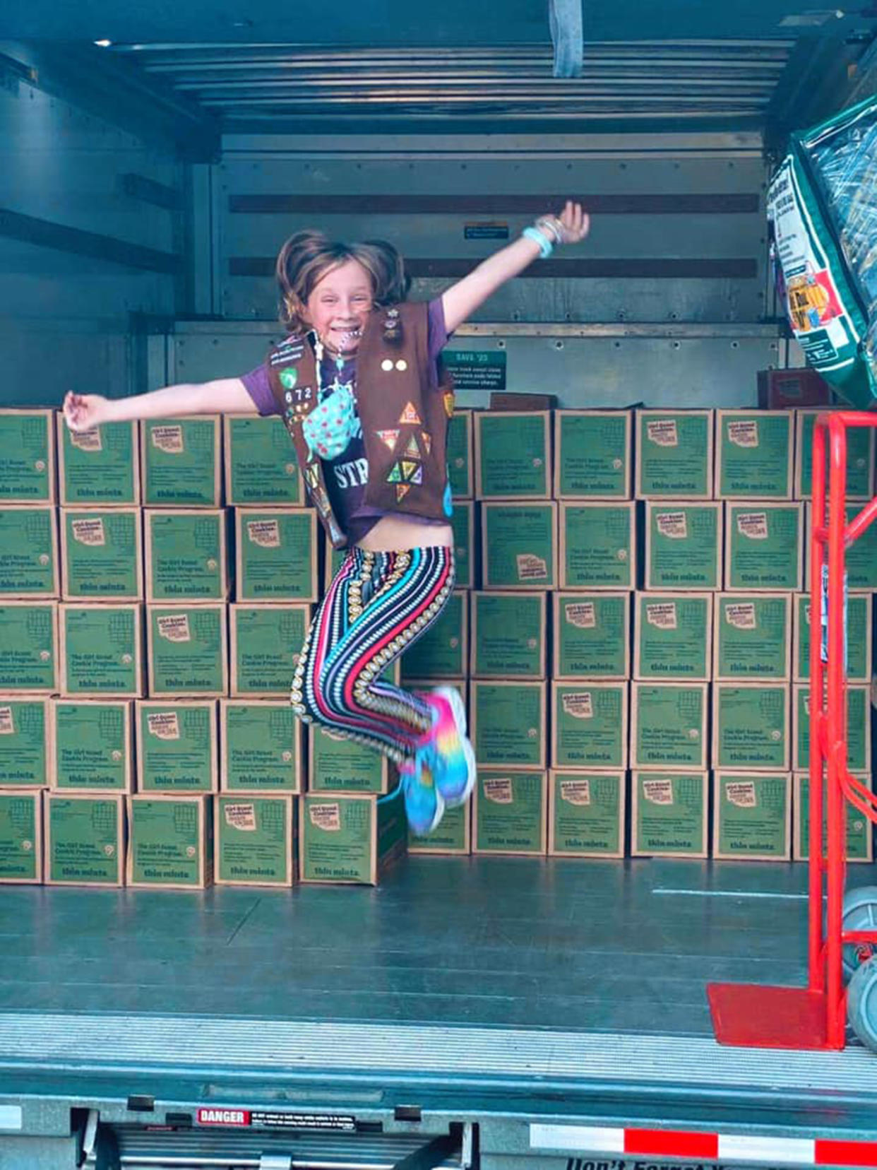 Lilly poses with the boxes of cookies her customers have donated to people in need this season. (Courtesy Trish Bauer)