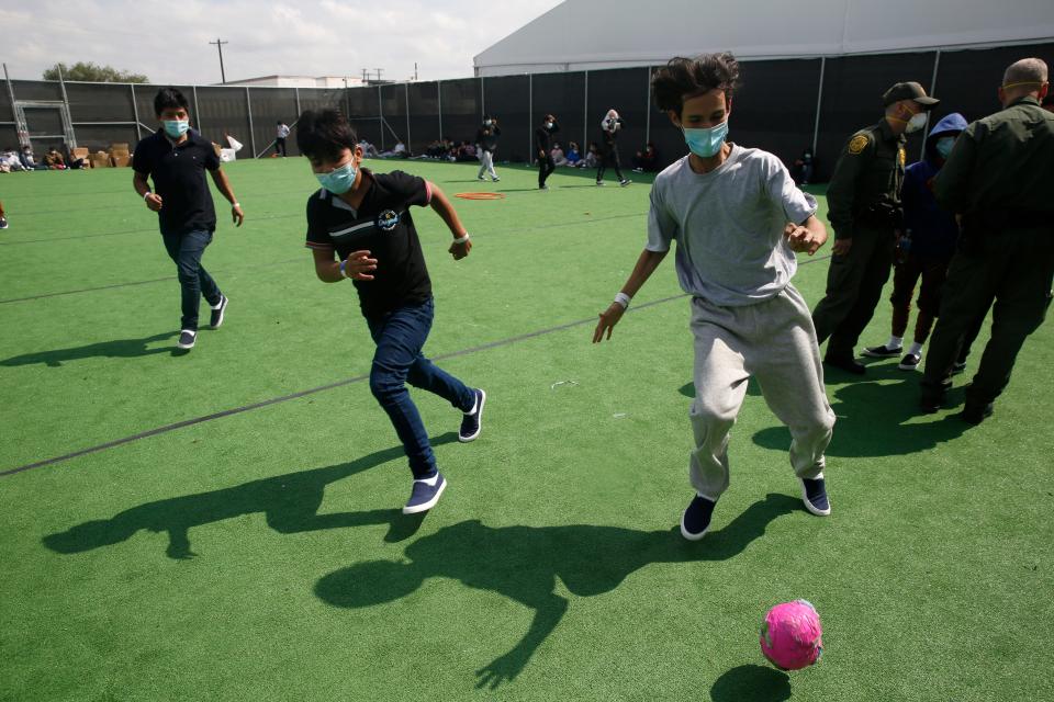 Minors play soccer on a field at the Department of Homeland Security holding facility run by the Customs and Border Patrol (CBP) on March 30, 2021 in Donna, Texas. The Donna location is the main detention center for unaccompanied children coming across the U.S. border in the Rio Grande Valley. The children are housed by the hundreds in eight pods that are about 3,200 square feet in size. Many of the pods had more than 500 children in them. The youngest of the unaccompanied minors are kept separate from the rest of the detainees. The Biden administration has just allowed journalists inside its main detention facility at the border for migrant children. It is an overcrowded tent structure where more than 4,000 kids and families are kept in pods, with the youngest kept in a large play pen with mats on the floor for sleeping. (Photo by Dario Lopez-Mills - Pool/Getty Images)